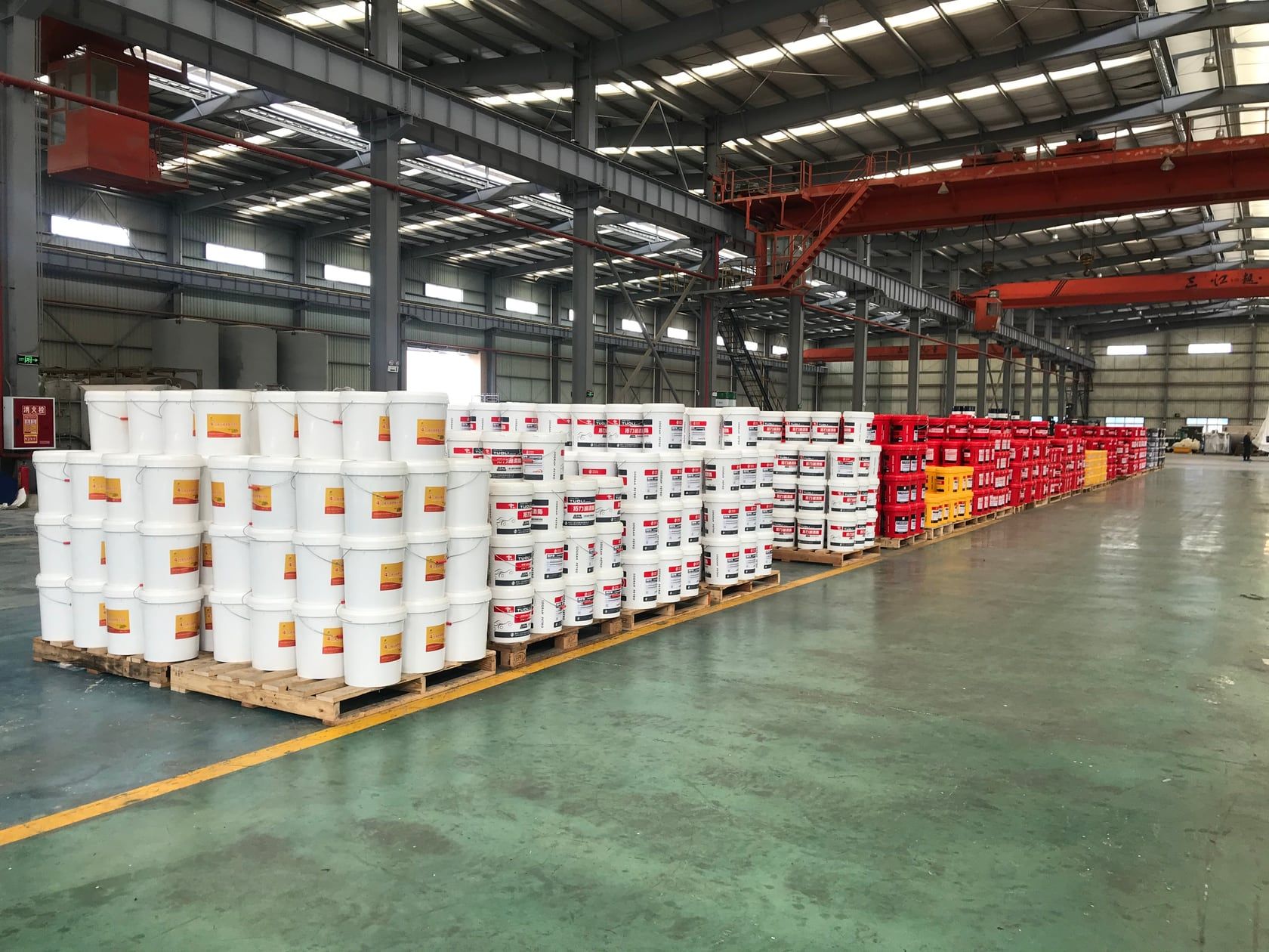 Rows of palletized lubricant pails in the finished-goods warehouse